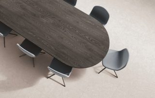 Top view of business room interior with black wooden table and chairs, carpet on grey concrete floor. Cozy conference space with minimalist furniture and sideboard. 3D rendering